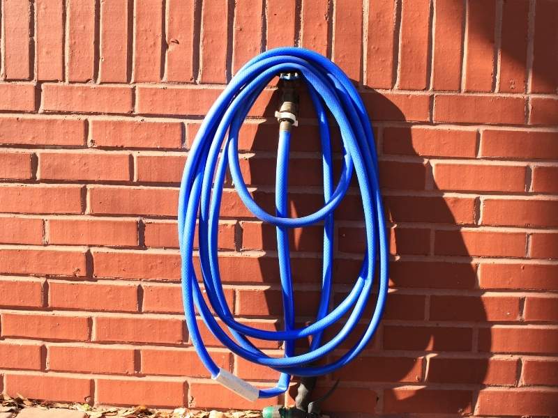 Exterior hose bib installed through a brick wall in Madison, AL, showing the masonry around the utility opening.