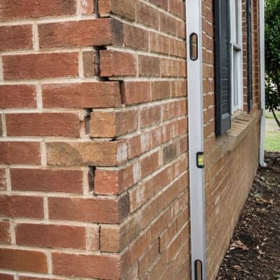 Exterior brick wall with uneven movement and visible bulging that may signal structural brick damage