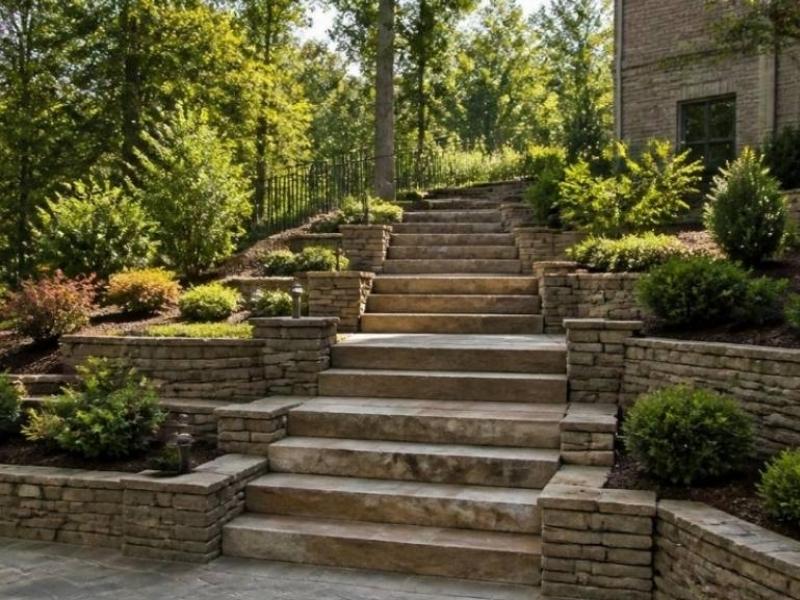 Stone retaining wall steps creating safe access across a sloped backyard in Madison, Alabama.