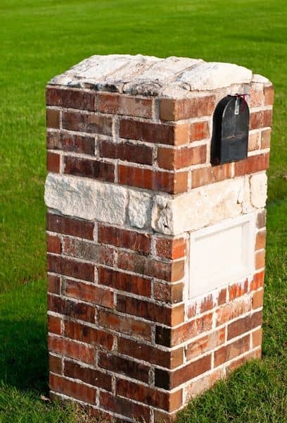 stone mailbox madisonbrickstone - Madison Brick & Stone Brick mailbox mounted on a stone-capped brick pedestal in a green front yard lawn, with a small black mailbox door on the side.