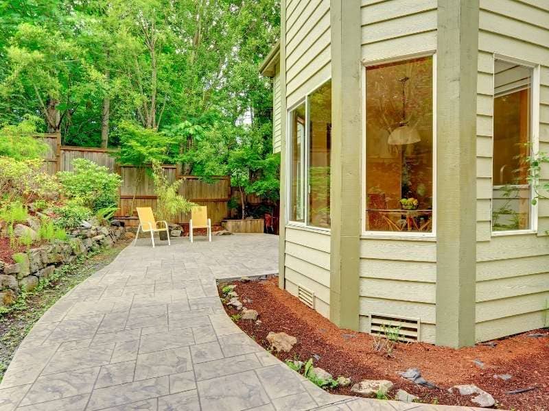 Stone patio outside a walkout basement door with drainage, pavers, and retaining wall features.

